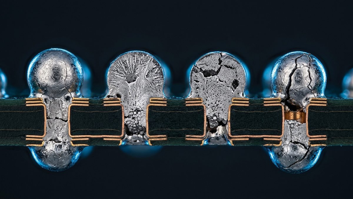 A close-up cross-section of a dark green circuit board shows a row of four silver solder joints filling copper-lined holes and bulging above and below the board, each with a different interior (one with thin cracks, one with a branching crystal pattern, one pitted with dark voids and one split by dark cracks), set against a dark blue background with partial joints cut off at the left and right edges.